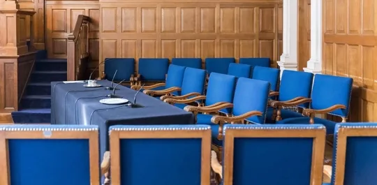 Empty formal conference room with blue chairs and wood paneling