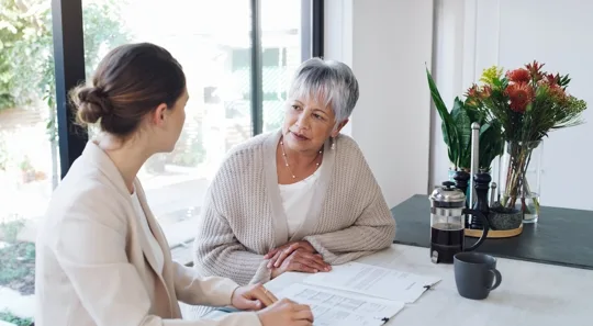 Advisor meeting with older woman at table