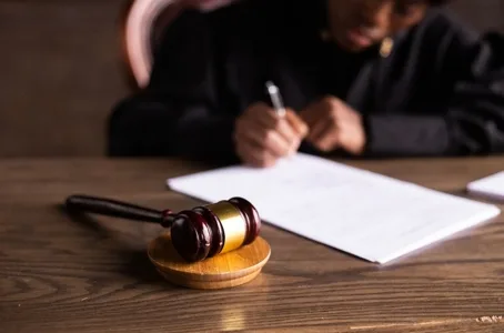 Judge or lawyer writing legal document with a gavel on the desk