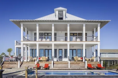 Large white coastal house with two-story porch and swimming pool