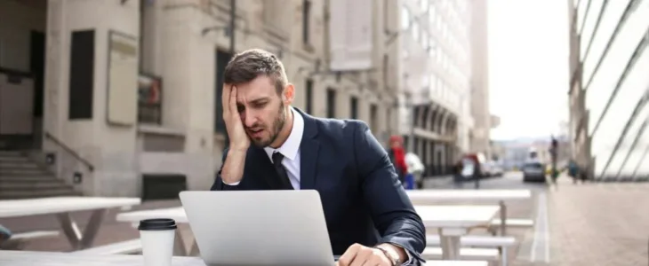 Stressed man with laptop outdoors