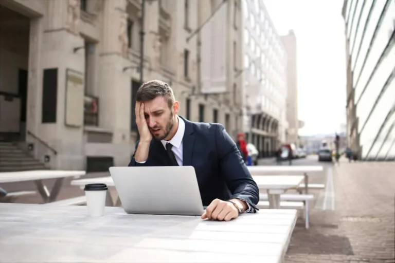 Stressed man with laptop outdoors