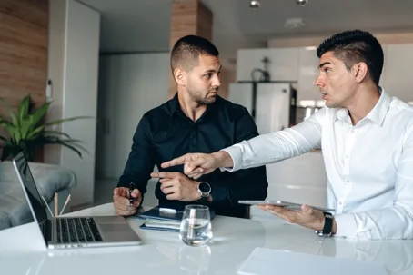 Colleagues discussing data at a laptop