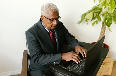 Senior man in suit using laptop