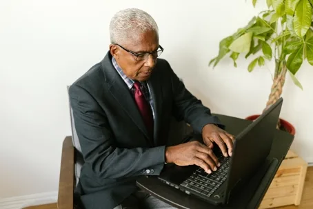 Senior man in suit using laptop