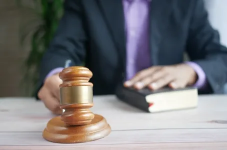 Judge’s gavel with hand on oath book