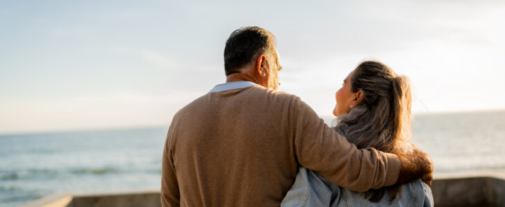 Senior couple walking and talking on coastline pier