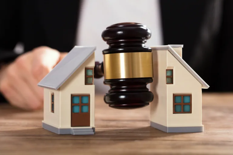 Close-up Of A Judge Striking Gavel Between Split House