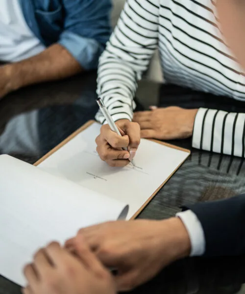 Close-up of hand filling paperwork at home