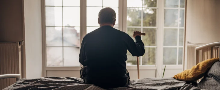 Elder man sitting on the bed