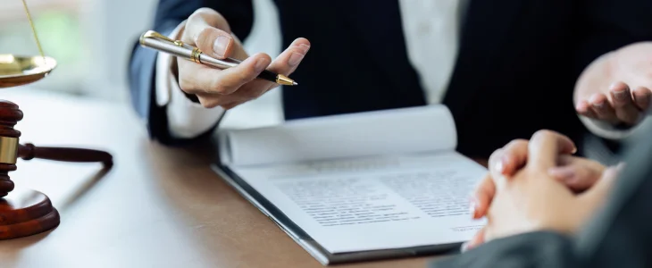 Lawyer points with pen at contract during consultation